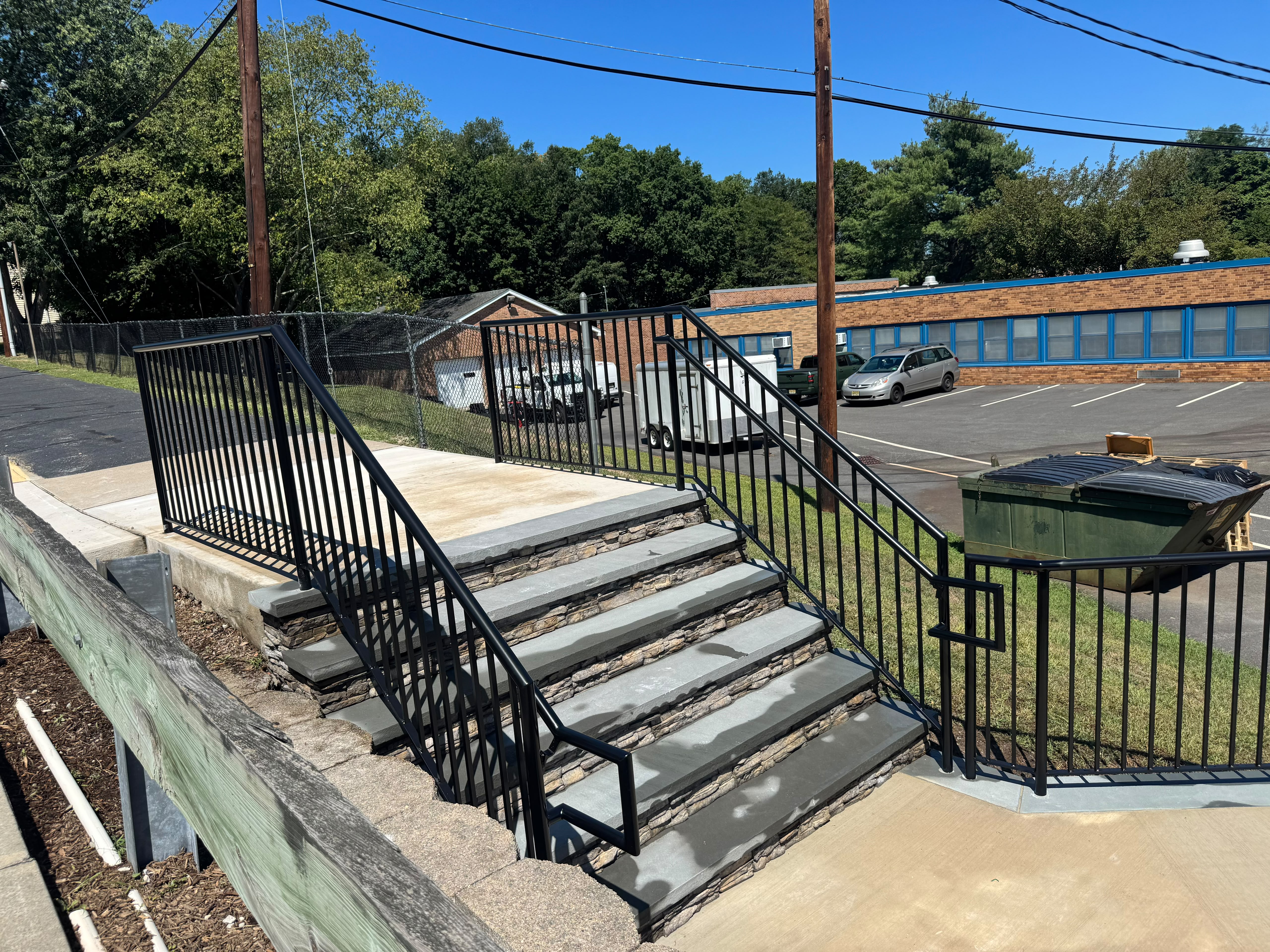 Black vertical-bar guardrails on the stone steps of a commercial plaza