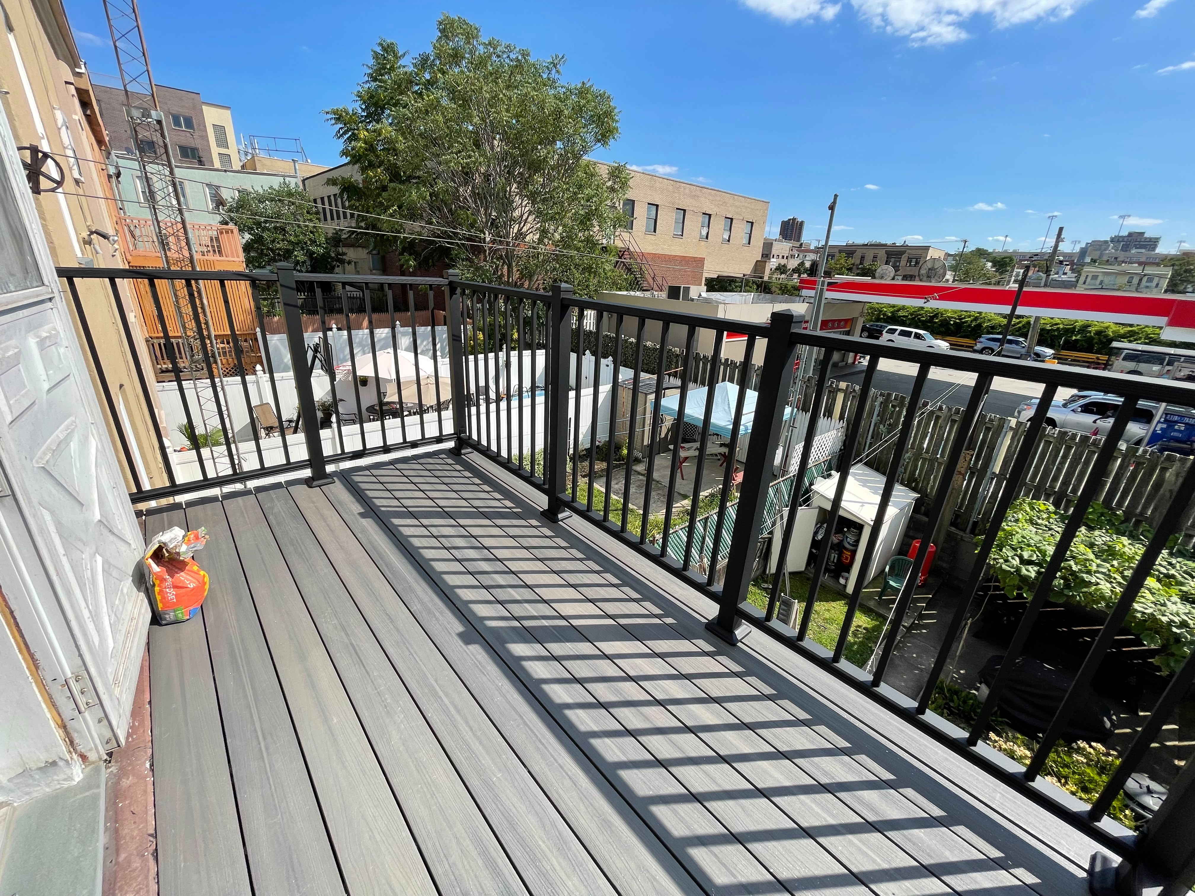 Black railing around a rooftop composite deck overlooking the surrounding neighborhood