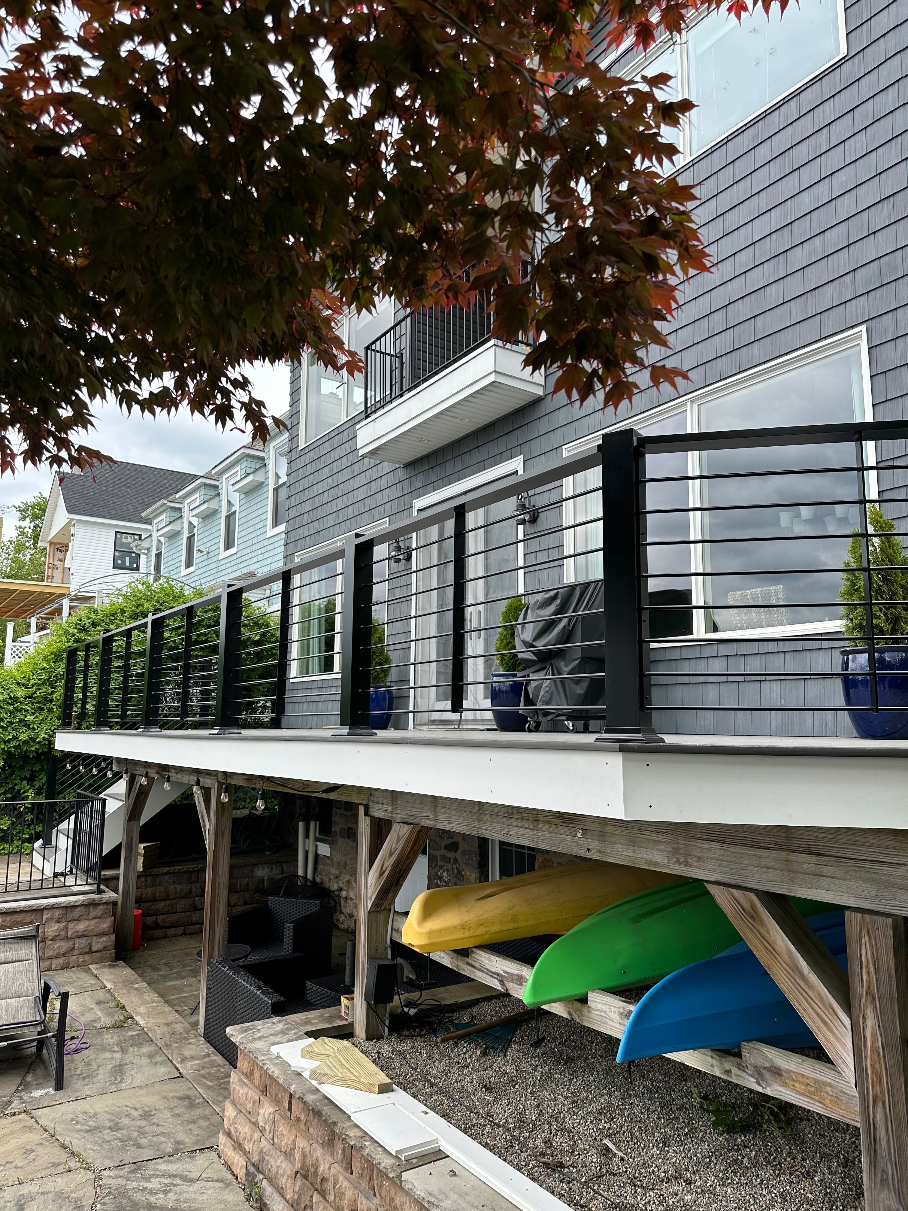 Black horizontal rod railing along a wraparound composite deck with lake views